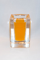 Liquid of poisonous bright color in a glass transparent vessel on a light background
