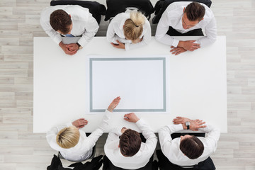 Business people sitting around empty table
