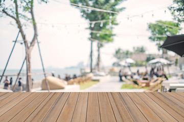 Wooden board table on blurry beach shop background