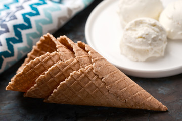 Ice cream balls, scoops and waffle cones on dark background. Advertising space.