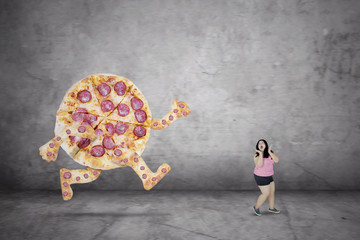 Overweight woman escaping from a pizza