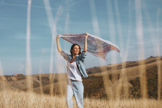 Young Woman Holding A Scarf In The Wind On A Mountain