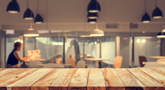 Wood table top with blur of people in coffee shop or (cafe,restaurant )background