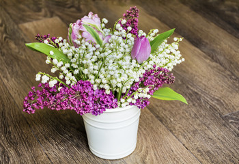 Bouquet of Purple Lilac and Lily of the Valley on a  Wooden Background.Spring Background