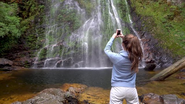Woman taking picture of Love waterfall in Sapa, Vietnam
