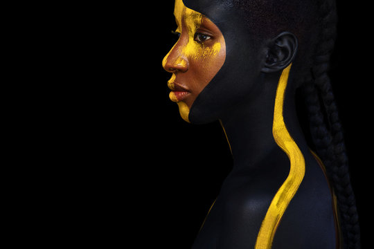 Cheerful young african woman with art fashion makeup. An amazing woman with black and yellow paint makeup