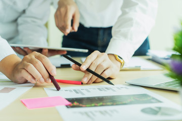 Two Business colleagues standing around boardroom table having informal discussion a new start up project.