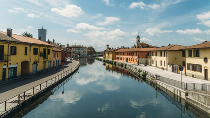 Cityscape of Gaggiano, just outside of Milan. Colourful houses reflected in the Naviglio Grande canal waterway