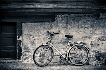 Modern bicycle standing on an old cobblestone covered street at a rugged stone wall