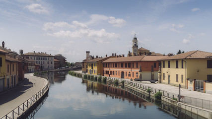Cityscape of Gaggiano, just outside of Milan. Colourful houses reflected in the Naviglio Grande canal waterway