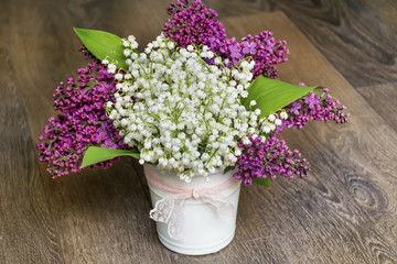 Bouquet of Purple Lilac and Lily of the Valley on a  Wooden Background.Spring Background