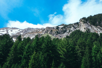 Beautiful view on the high green mountains peaks, on the blue sky background. Mountain scenic paradise landscape, spring.