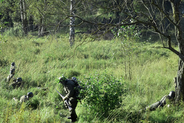The military in the forest with weapons and in military uniforms conduct military operations