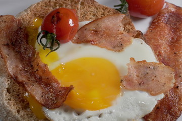 Fried egg with smoked turkey bacon and cherry tomatoes.