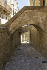 Fototapeta na wymiar Ancient street in Matera, with arched bridges