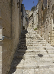 Fototapeta na wymiar Historic ancient stone staircase in a narrow alley in the historic sassi district of Matera