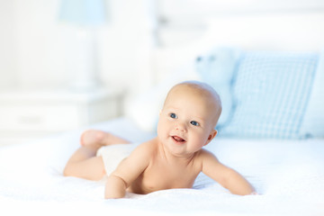 Baby boy on white bed