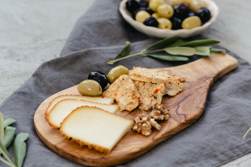 Cheese board with olives and walnuts.