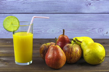 A glass of freshly squeezed orange juice, pears and apples