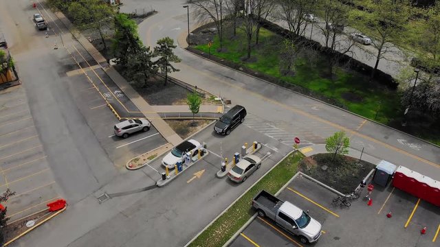 An aerial view of cars entering and leaving a parking lot.  	