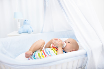 Baby drinking milk. Boy with formula bottle in bed