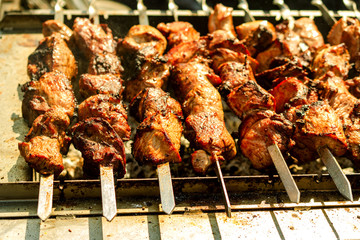 Meat on grill or shish kebab process of cooking. Fried on the on skewers on hot charcoal. Traditional eating for picnic.