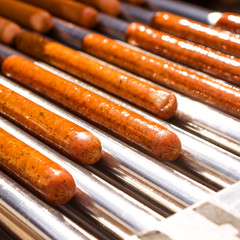 Automatic electric grill with sausages. For cooking. Can be used show how delicious appetizers are prepared and hot dogs. Square.