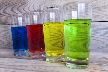 Multicolored lemonade on a wooden background