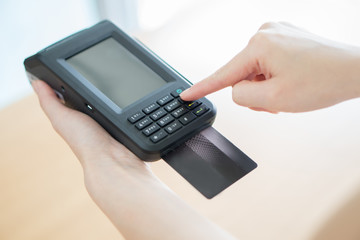 Hand with credit card swipe through terminal