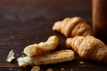 Puff pastries on dark wooden table, close-up, selective focus, shallow depth of field.