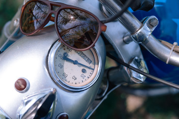 Fototapeta premium motorcycle parts headlight with sunglasses vintage retro motorbike. old timer age concept, 1960s style, outdoor dirt road