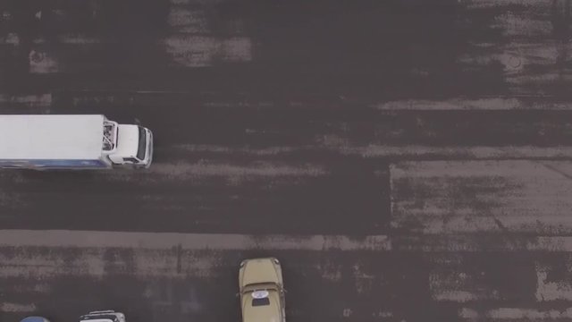 Flying above truck, car going along the road.