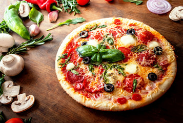 Food ingredients and spices for making Pizza  with  mushrooms, tomatoes, cheese and basil leaf  on wooden background closeup. Top view. Pizza Ready to Eat.