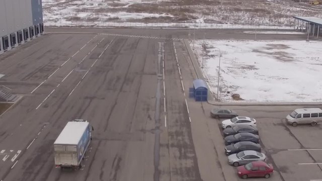 Flying above truck, car going along the road.