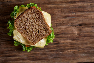 Tasty and fresh sandwiches on a dark wooden table, close-up
