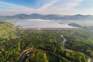 Aerial view of rural village with dam and river green forest