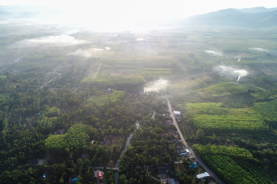 Aerial view of rural village with dam and river green forest