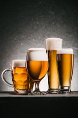 close up view of arranged mugs of beer on grey background