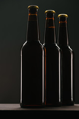 close up view of arranged bottles of beer on dark backdrop