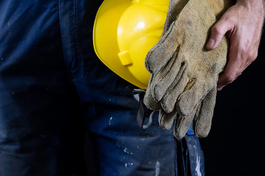 Protective gloves for construction workers and welders. Protective clothing used by builders. Dark background.