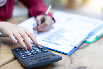 Woman hands working with calculator about personal financial planning at home office.