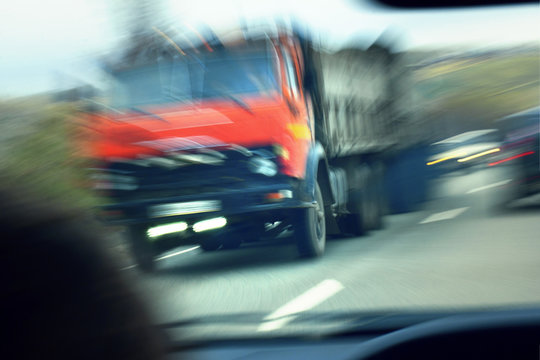 truck with red cab on the road in motion. Accident rate
