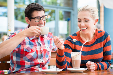 Couple, woman and man, having coffee in a street cafe in Berlin