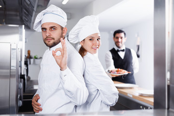 Portrait of team of professional restaurant cooks in kitchen