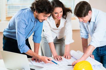 Civil engineers and architects talking about ground plot for building
