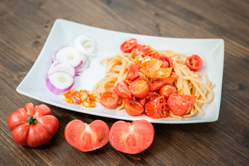 Spaghetti with tomato sauce with fresh Tropea onion.
