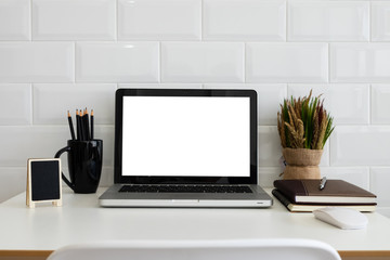 Mockup blank screen laptop on desk. Workspace with laptop and office supplies.