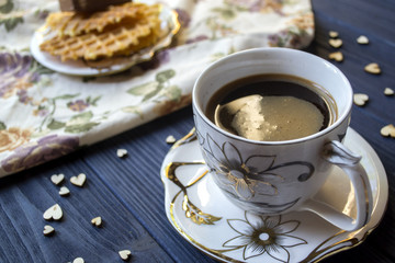 A cup of coffee and dessert on a rustic table.
