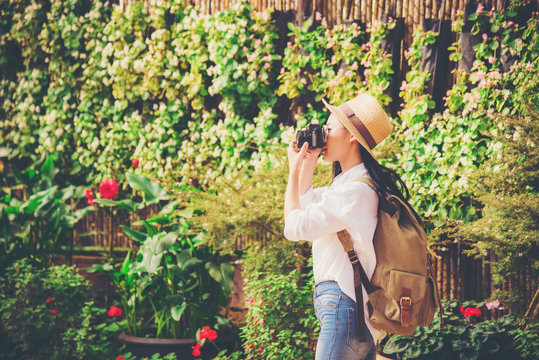 young woman taking a photo at a beautiful garden in springtime.