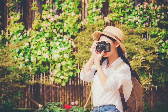 Beautiful woman taking photo tourist in flower garden